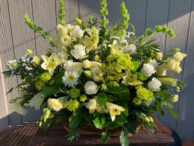 Large sympathy fireside basket of white lilies, roses, and green flowers