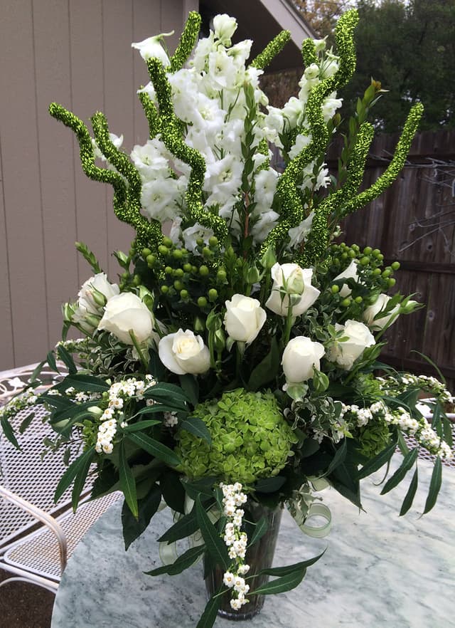 White and green anniversary party arrangement of roses and hydrangea