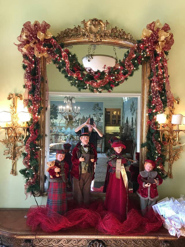 Mirror framed with custom ribbon garland and Victorian caroler figures
