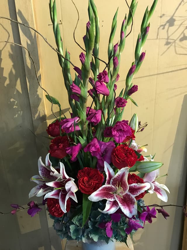 Magenta gladiolas and stargazer lilies in a tall arrangement
