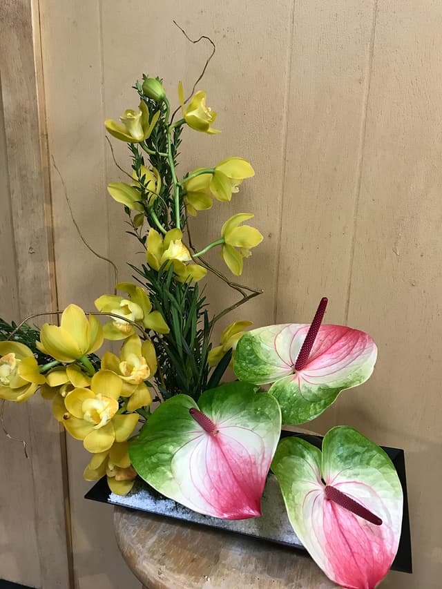 Ikebana-style design with anthurium, yellow orchids, and sculptural lines