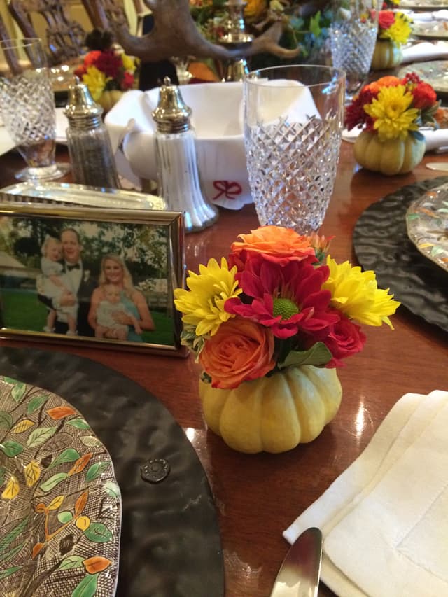 Mini pumpkins with flowers used as place card holders