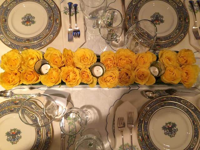 Pavé runner of yellow roses with floating candles down a formal table