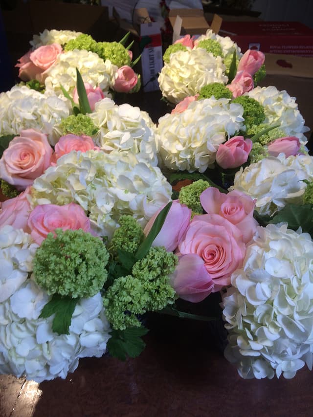 Pink and white centerpieces of hydrangea, roses, and sweet peas
