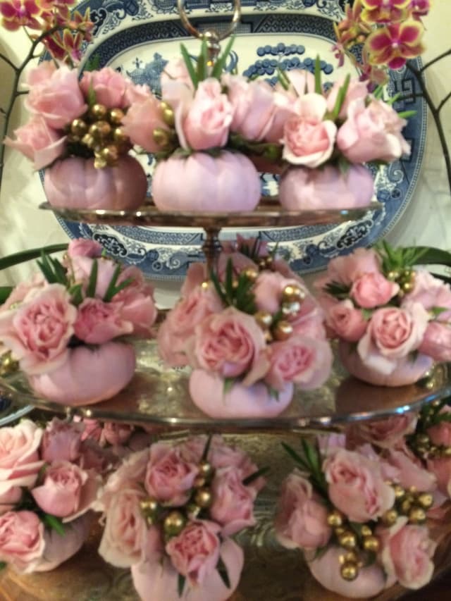 Pale pink roses arranged in mini pumpkins on a tiered stand