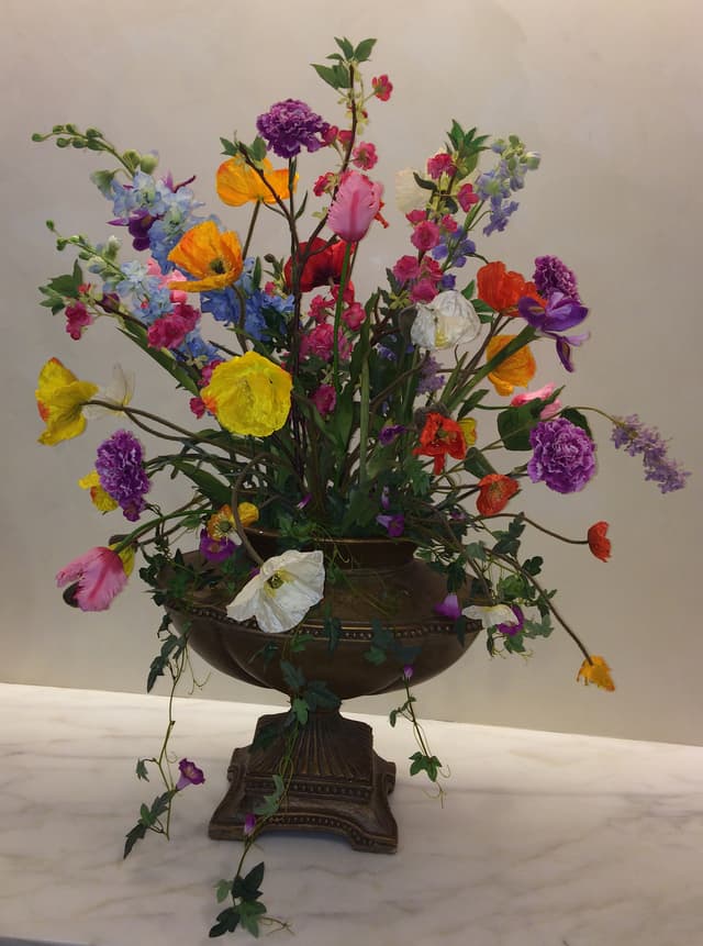 Colorful silk spring poppies in a footed urn