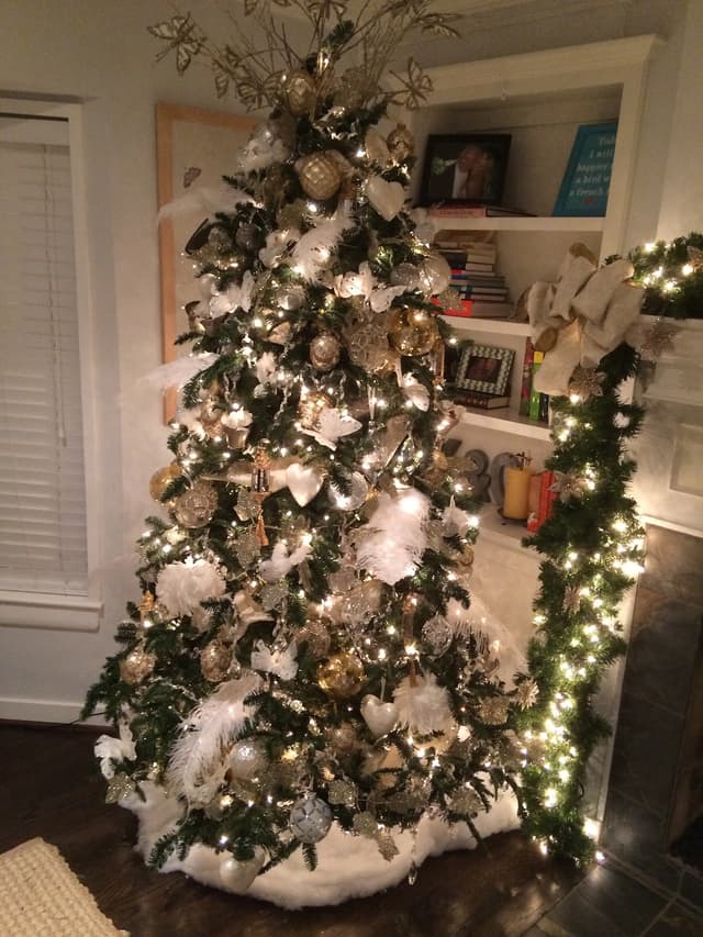 Christmas tree decorated in white, metallics, and feathers